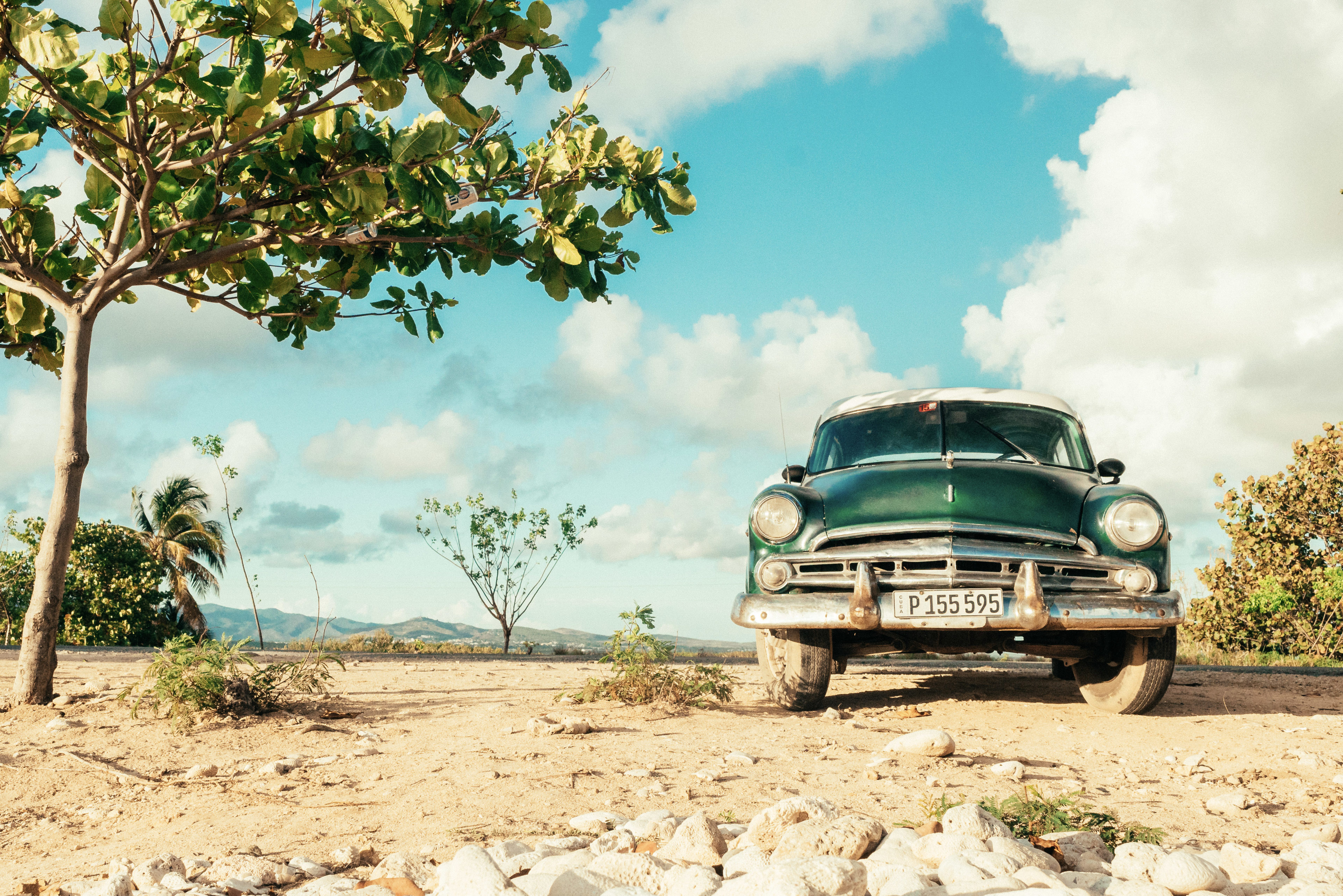 Ein Oldtimer steht in einer steppenartigen Landschaft in Kuba