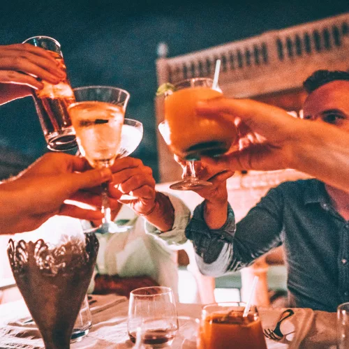 Eine Gruppe stößt mit Cocktails in Kuba an.